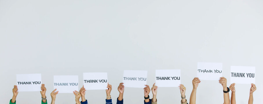 Studio shot of variety fonts thank you letters paper sign holden above head by group of unrecognizable unidentified faceless officer staff showing appreciation to customers on white background