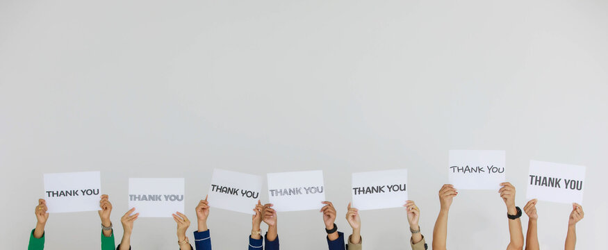 Studio shot of variety fonts thank you letters paper sign holden above head by group of unrecognizable unidentified faceless officer staff showing appreciation to customers on white background