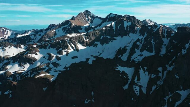Aerial footage over snow frosted mountain peaks. 