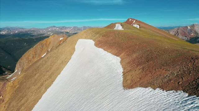 Aerial footage over snow frosted mountain peaks. 