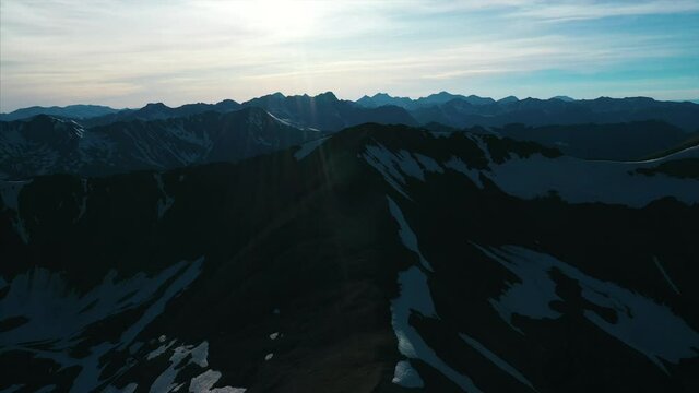 Aerial footage over snow frosted mountain peaks. 