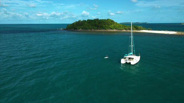 Drone tracks Catamaran in exotic island destination. 