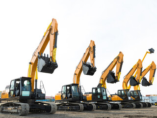 New Yellow Excavators are lined up in an open area