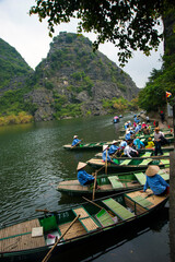 Fototapeta na wymiar C'est le paysage à Ninh Binh au Vietnam. Les gens des bateaux à rames. À Trang An