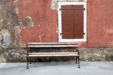 bench in front of a wall with old window in škrbina cars kras slovenia - obrazy, fototapety, plakaty