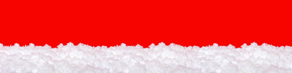 Snow on a red background. Christmas theme, large format, panoramic photo for a banner or website header. Christmas greeting card for printing.