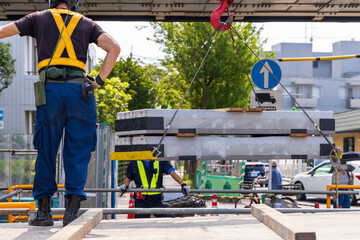 トラックの荷台から資材を下ろす作業員