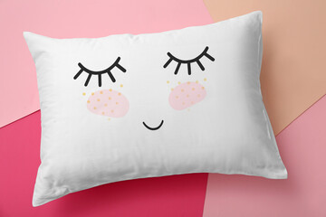 Soft pillow with cute face on color background, top view