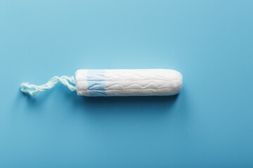 Hygienic tampon on a blue background with a free space