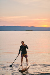 Man enjoying paddling the board on the lake