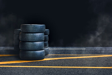 Tire pile on the asphalt road with smoke at night and black background,copy space