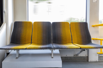 Photograph of a four-seater seat in a DVB streetcar. a yellow, dark gray pattern on a bench seat.