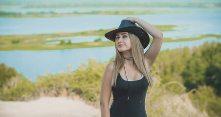 Girl in American country style black boho jacket with a fringe and cowboy hat at nature