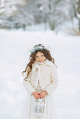 Fototapeta na wymiar Adorable little girl holding Christmas lantern outdoors on beautiful winter snow day