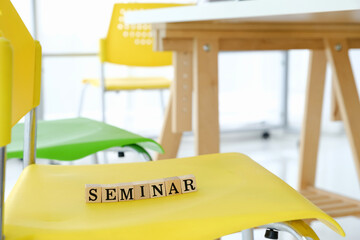 Text wooden cubes spelling is seminar on the chair in meeting room