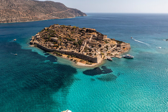 panoramic view of Spinalonga island with ships and turquoise sea filmed from a drone 