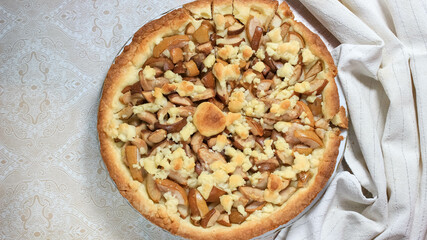 A whole charlotte in a plate, which is cut into even pieces. Baking for tea.