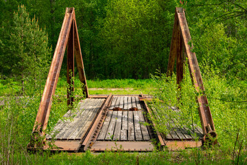 Old wooden and metal railway turntable surrounded by trees and other plants in Finland. © Jemelee Alvear