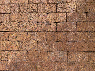 Laterite brick wall background and texture. Natural Laterite rock for outdoor and tropical garden or Bali garden wall decoration. Selective focus