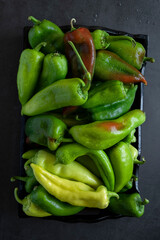 Raw peppers on dark background, food backdrop. Vegetable nutrition ingredients