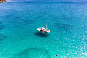 panoramic view of the sea and mountains and ships on turquoise water filmed from a drone