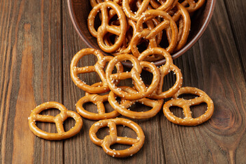 Pretzels in a ceramic bowl on wooden background close up. Pretzels flat lay, top view