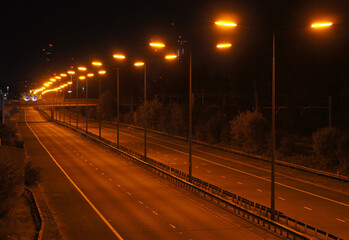 Motorway, freeway or highway at night with orange sodium street lighting. M602, England, UK. No traffic. © Callum