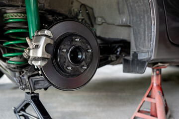Rear wheel disk caliper and car wheel hub service and check in process of maintenance in garage