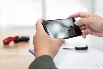 Hand a man hold smartphone take a photo of Car crash accident and document ,car key on table:...