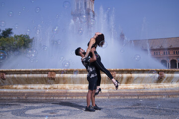 Fototapeta na wymiar Multi-ethnic young couple doing figures while dancing bachata sensually outdoors.