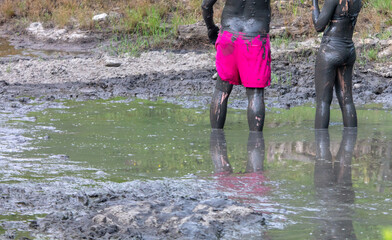 A man and a girl in the healing mud.