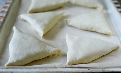 Step by step instructions. Step seven. How to make a puff pastry product with meat at home. Put the product ready to bake on a baking sheet. The baking sheet is covered with parchment paper.