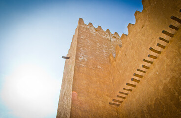 Historic arabic buildings, Barzan Watch towers made from Limestone and coral stone against a blue sky. Qatar, Middle East, no people.