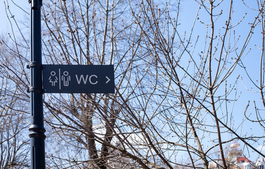 Toilet sign on a post in the park. WC sign for men and women.