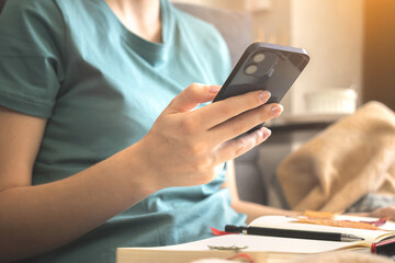 Girl using smartphone at home sitting on sofa with warm plaid. Cozy autumn background photo