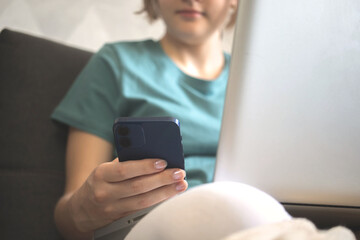 Happy young girl using mobile phone indoors in cozy autumn day and weekends
