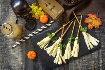 Halloween funny idea for party food. Halloween creative cheese snack on a wooden table. Top view flat lay background.