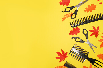 Professional hairdresser tools on autumn yellow background with red falling leaves , copy space