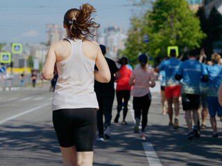 Adult tall woman running marathon in city