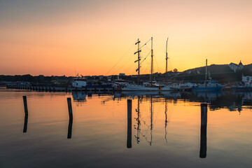 Fototapeta na wymiar Segelschiff und Fischerboot im Hafen von Sassnitz auf der Insel Rügen am Abend