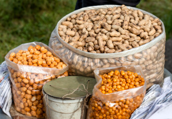 Peanuts, fried pea, and snacks on a bowl close up