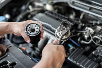 Close up wrench in hand a man with oil filter change in engine room service concept of car