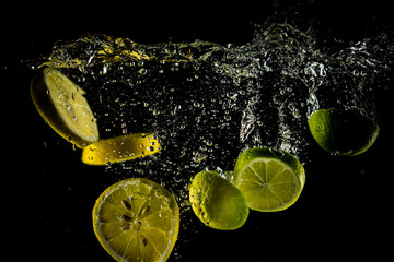 Fototapeta na wymiar Lemon and lime splash in water
