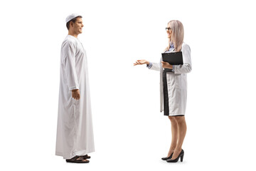 Full length profile shot of a female doctor talking to a young male patient in ethnic clothes