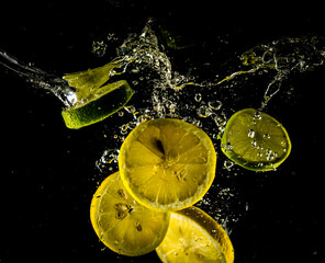 Fototapeta na wymiar Lemon and lime splash in water