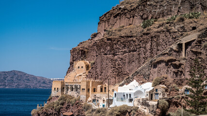Old port of Thira on Santorini island in Greece. Aegean sea. Sunny day. Ancient architecture building in rock.