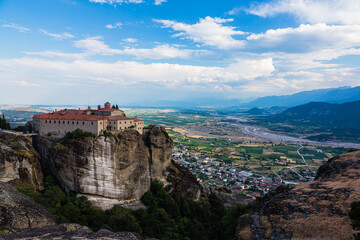 Fototapeta na wymiar ギリシャ　メテオラの断崖絶壁の岩山の上に建つ聖ステファノス修道院と奇岩群の隙間から覗くカランバカの街並み