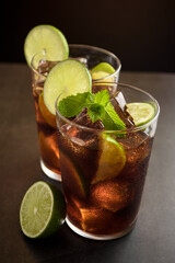 Cuba Libre cocktail. Alcoholic drink with cola, rum, lime and mint. Cuba Libre or long island iced tea cocktail.