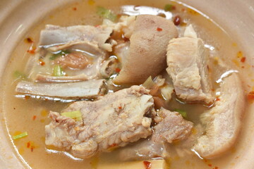 hot and spicy pork bone with tamarind and Thai herbs soup on bowl dipping chili sauce
