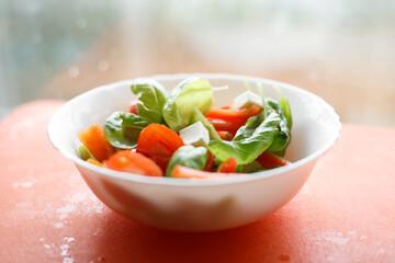 fresh vegetable salad. salad with white cheese, pepper, tomatoes and basil. A close up view of a fresh bright garden salad with all the delicious ingredients. Blurred background